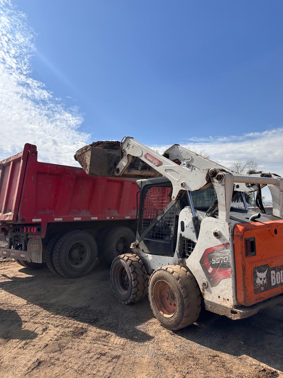 Camión tolva rojo de gran capacidad durante operación de carga de materiales